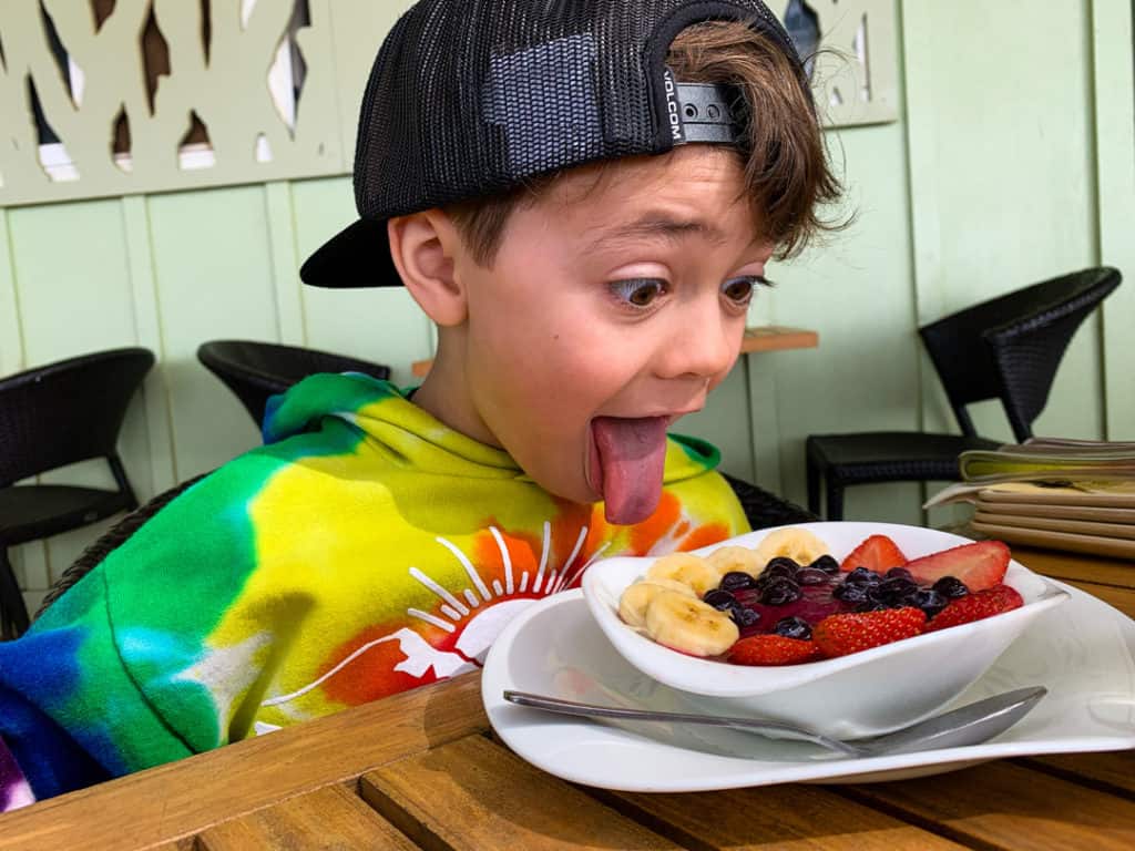Boy looking excitedly at acai bowl for breakfast