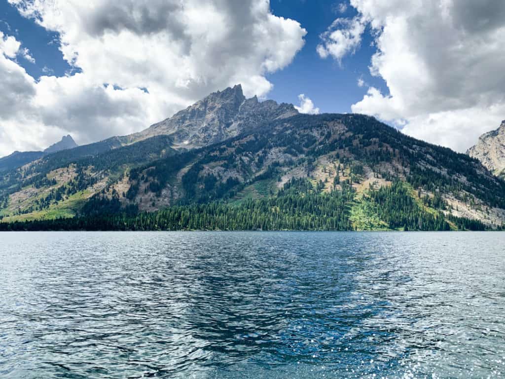 Teton mountains rising out of the teal blue water of Jenny Lake