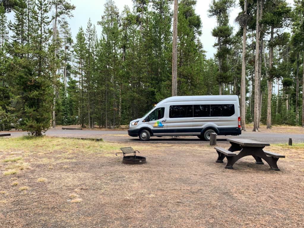 wandervans campervan at campsite in Grant Village Campground in Yellowstone with firepit and picnic table in foreground