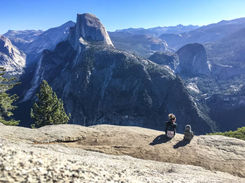 image of mother and sun sitting on rock at Glacier Point in Yosemite National Park