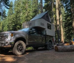 Scout Campers Kenai on F350 Tremor with rooftop tent in place setup at campsite
