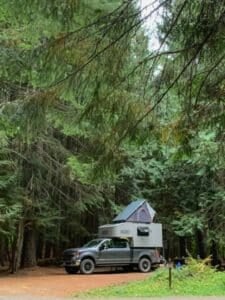 Scout Campers Kenai set up at campground with rooftop tent under evergreen trees