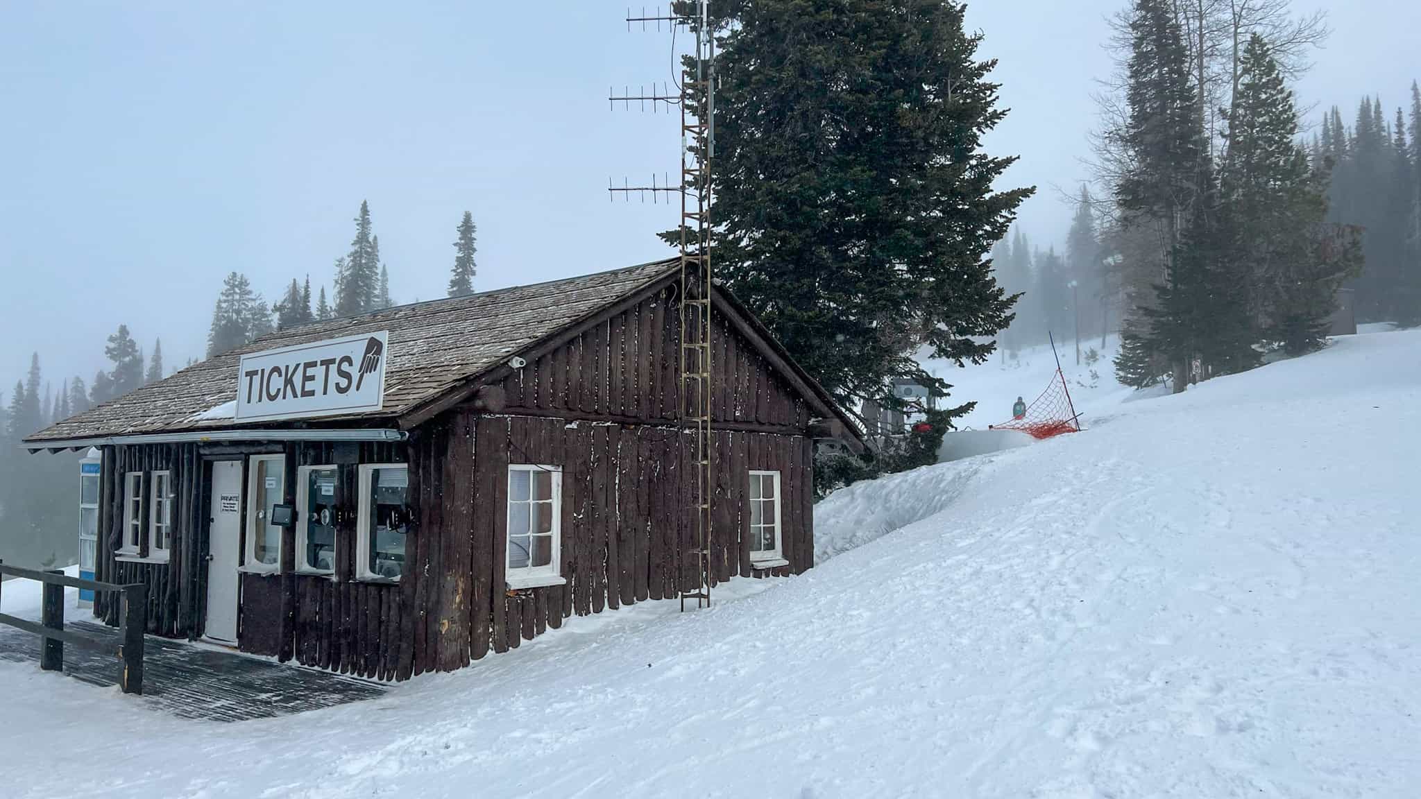 Is the Indy Pass Worth It? Your Comprehensive Indy Pass Review & Buyers' Guide 10 snow resort ticket booth building during storm at Pomerelle Mountain
