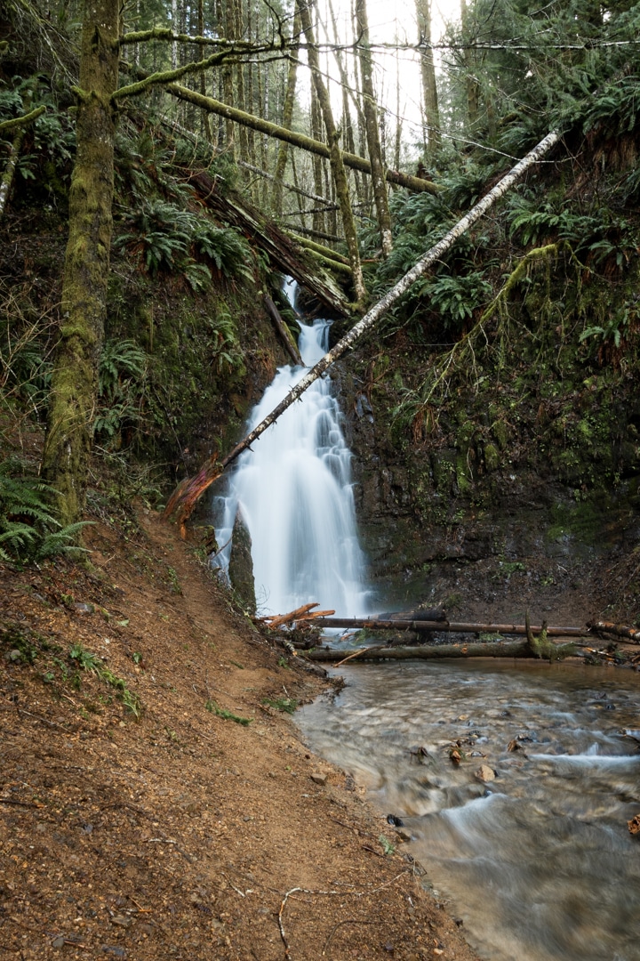 long exposure showing silky flow of waterfall to small stream at the base
